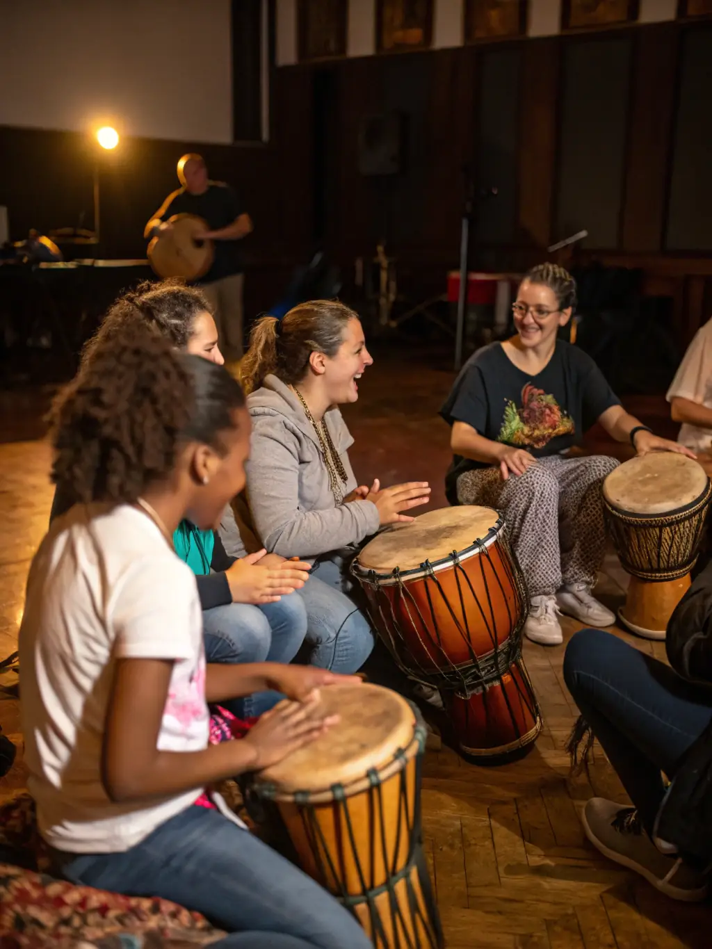 An image of a diverse group of people playing various percussion instruments in a drum circle, with smiling faces and a sense of community.